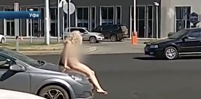 Совершенно голая девушка вышла на проезжую часть и села на капот машины